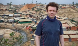 Michael Sheen on a hill overlooking a refugee camp