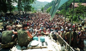 Dutch UN peacekeepers sit on top of an armoured personnel carrier as Muslim refugees from Srebrenica gather in the nearby village of Potocari in July 1995.